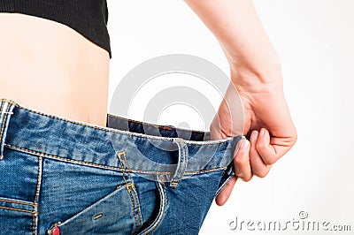 Thin white woman wearing loose jeans. White background. Exercise Stock Photo
