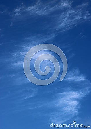 Thin wispy cirrus clouds seen against blue sky Stock Photo