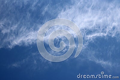 Thin wispy cirrus clouds seen against blue sky Stock Photo