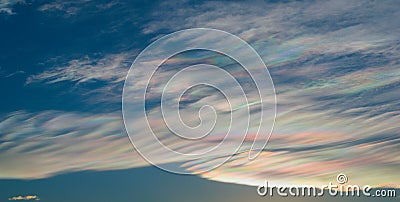 Thin wispy clouds creating rainbow patterns of scattered sunlight. Optical phenomenon on cirrostratus clouds Stock Photo