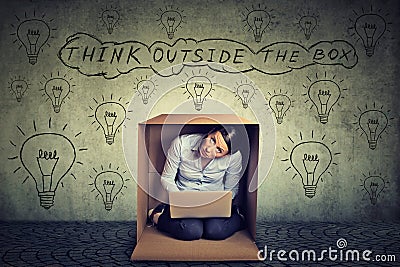 Think outside the box concept. Woman sitting inside box using working on laptop computer Stock Photo