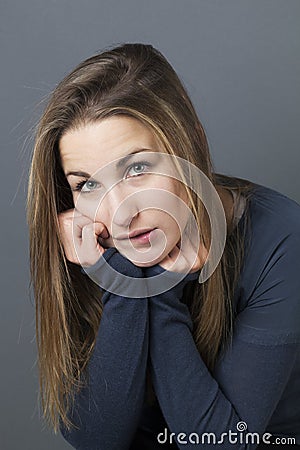 Thinking beautiful young girl looking shy or having regrets Stock Photo