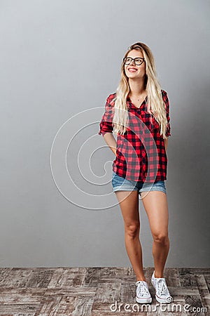 Thinking cheerful young blonde woman standing isolated Stock Photo