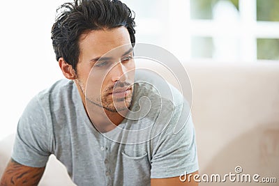 Thinking, depression and face of man on sofa with stress, anxiety or broken heart at home. Fail, crisis or male person Stock Photo