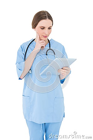 Thinking female doctor holding a tablet Stock Photo