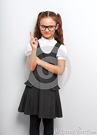 Thinking happy smiling pupil girl in fashion eyeglasses with fin Stock Photo