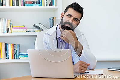 Thinking latin american mature doctor with hipster beard Stock Photo