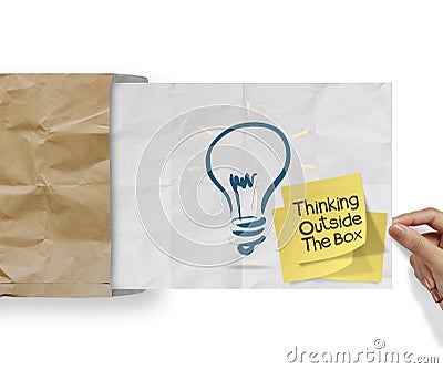 thinking outside the box on sticky note and lightbulb as creative on crumpled envelope paper Stock Photo