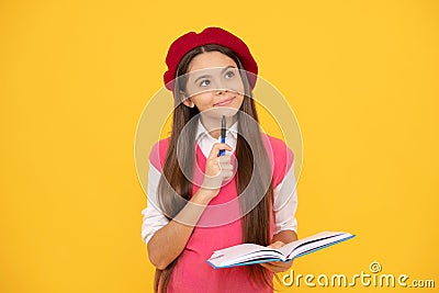 thinking teen school girl in french beret making notes in planner notepad or notebook, education Stock Photo