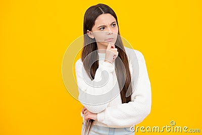 Thinking teenager girl, thoughtful emotion. Smart nerdy school girl touching cheek and thinking against yellow Stock Photo