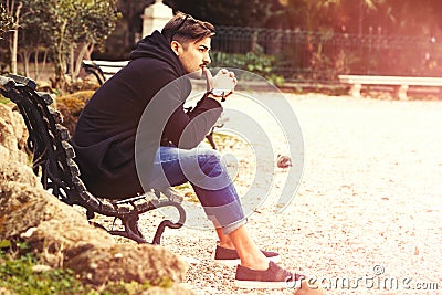 Thinking, thoughtful handsome man on the bench. Outdoors Stock Photo