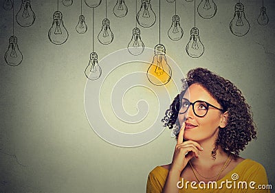 Thinking woman in glasses looking up with light idea bulb above head Stock Photo