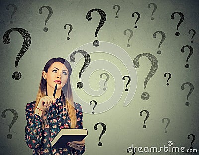 Thinking woman looking up at many questions mark Stock Photo