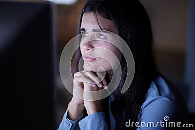 Thinking, working and woman in office at night reading information on computer while doing research. Overtime Stock Photo