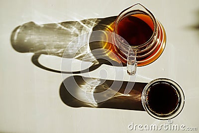 Third wave specialty coffee aesthetics. Freshly brewed black pour over coffee on sunlit white table Stock Photo