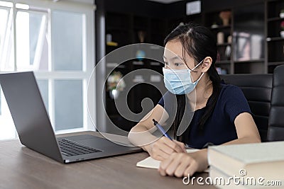Thirsty asian child girl drink water from a glass while sitting in bed after waking up in the morning,beautiful female enjoy Stock Photo