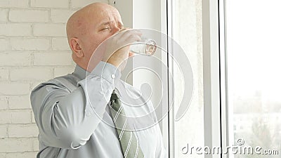 Thirsty Person Drinking Fresh Water from a Glass near Window in Office Room Stock Photo
