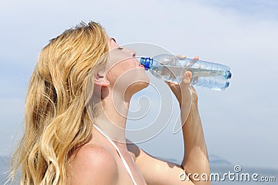 Thirsty woman drinking water outdoors Stock Photo
