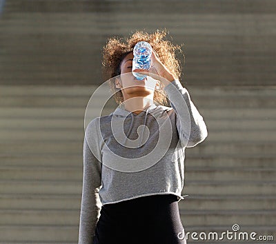 Thirsty young woman drinking from water bottle Stock Photo