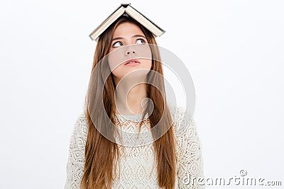 Thoughtful amusing young woman with book on her head Stock Photo