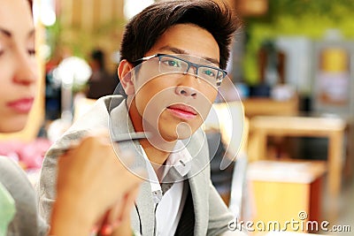 Thoughtful asian man in glasses at office Stock Photo