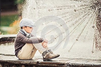 Thoughtful boy by the fountain Stock Photo
