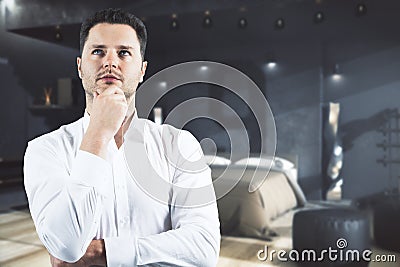 Thoughtful businessman in blurry bedroom Stock Photo