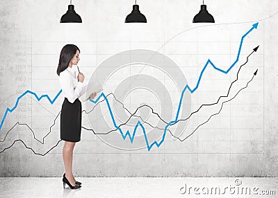 Thoughtful businesswoman with copybook, graphs Stock Photo