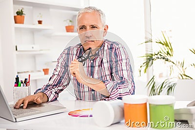 Thoughtful casual businessman sitting at working desk Stock Photo