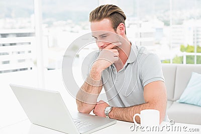 Thoughtful casual businessman working with laptop Stock Photo