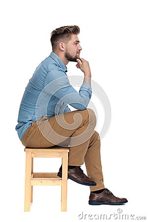 Thoughtful casual guy holding hand to chin and thinking Stock Photo