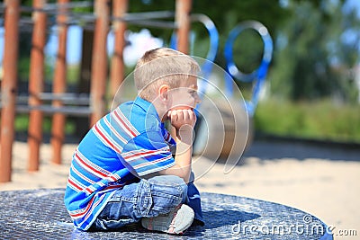 Thoughtful child boy or kid on playground Stock Photo