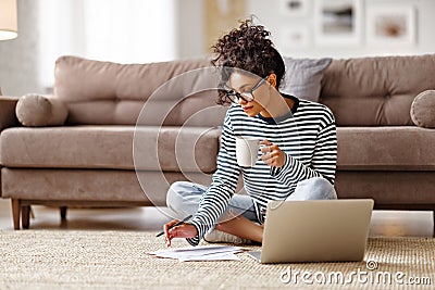 Thoughtful ethnic woman doing paperwork at home Stock Photo