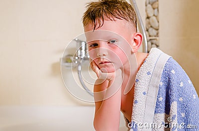 Thoughtful glum little boy draped in a towel Stock Photo