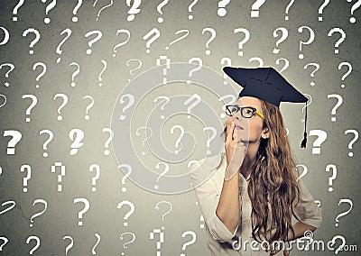 Thoughtful graduate student woman with many question marks above head Stock Photo