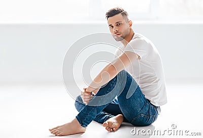 Thoughtful handsome man portrait sitting on floor Stock Photo