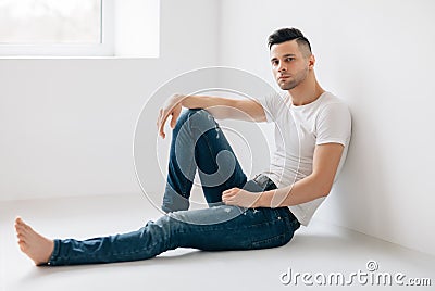 Thoughtful handsome man portrait sitting on floor Stock Photo