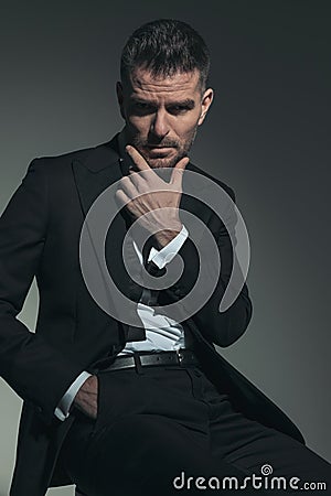 Thoughtful handsome man in suit posing with hand in pocket Stock Photo