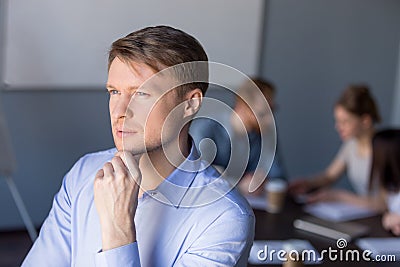 Thoughtful male employee looks in distance thinking about succes Stock Photo