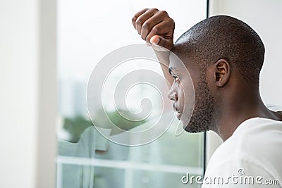 Thoughtful man looking out the window Stock Photo