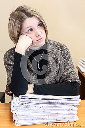 Thoughtful office employee sitting next to documents Stock Photo