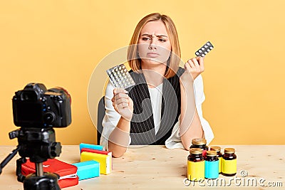 Blogger girl has headache, chooses what pill to take, needs quick pain relief Stock Photo