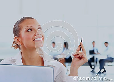 Thoughtful smiling business woman on the background of colleagues in the office. Stock Photo