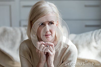 Thoughtful upset mature lady crying thinking of loneliness or gr Stock Photo