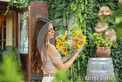 Thoughtful Woman Admiring a Bouquet of Sunflowers Stock Photo