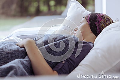 Thoughtful woman battling with lupus looking out of window at home hospice Stock Photo