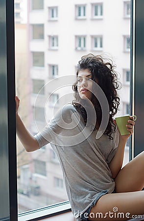 Thoughtful woman in the city apartment Stock Photo