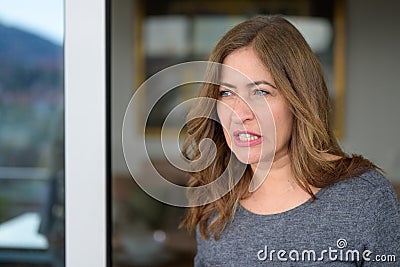 Thoughtful woman grinding her teeth in concentration Stock Photo