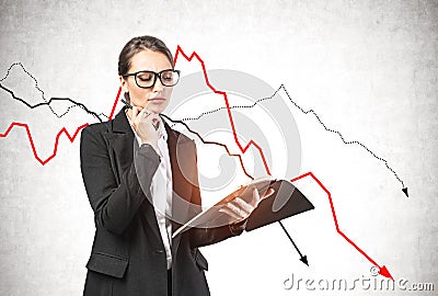 Thoughtful woman with notebook, falling graph Stock Photo