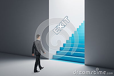 Thoughtful businessman in concrete interior looking at blue stairs exit. Way out, solution and choice concept Stock Photo